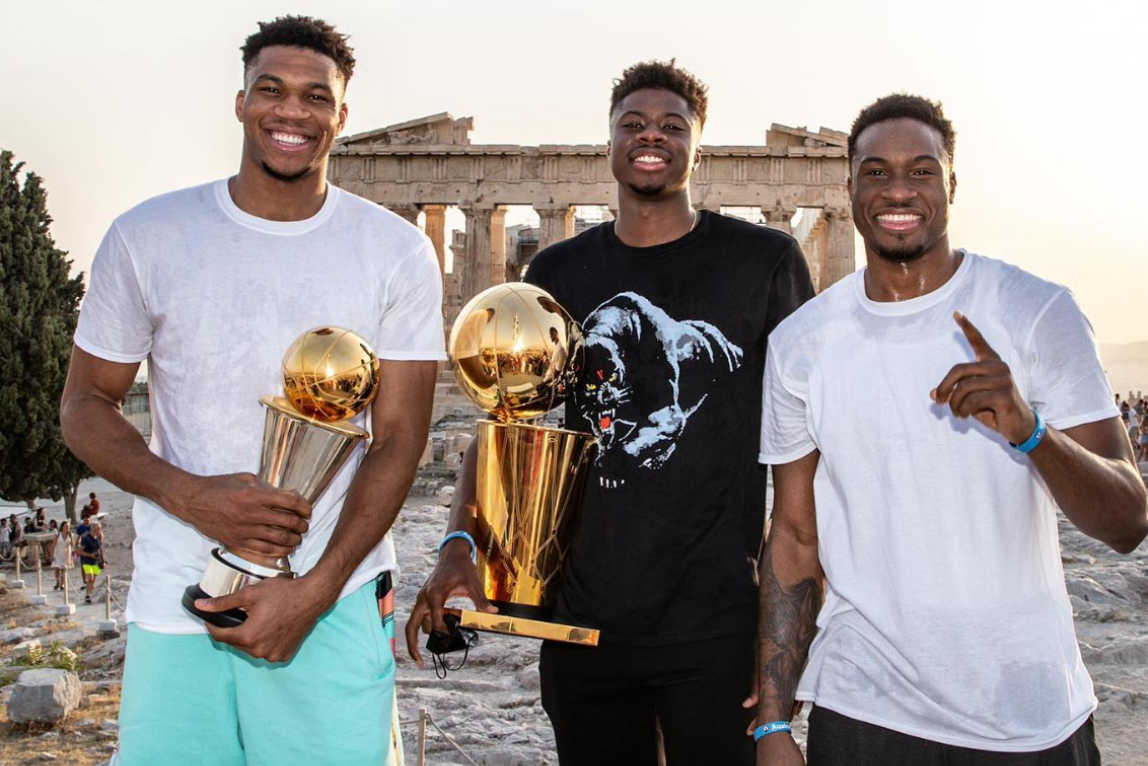 Giannis and brothers holding trophies